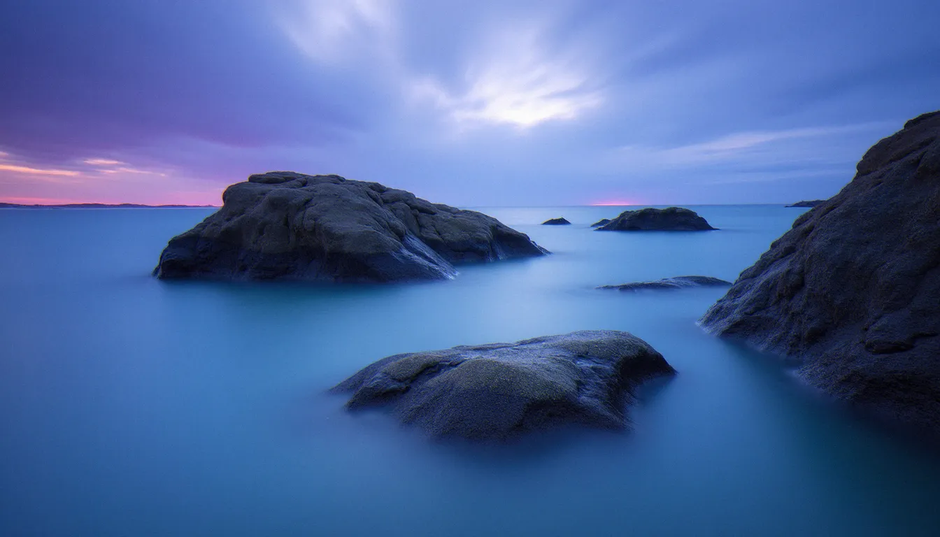 Longue exposition à la pointe de Lomener près de Guidel, rochers granitiques entourés d'une mer lissée à l'heure bleue, tons violets et bleus dans le ciel
